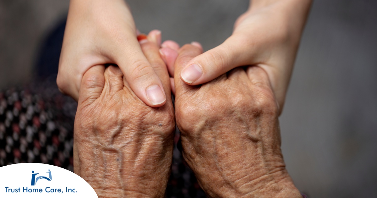 Younger hands hold older ones, representing the care and compassion of caregiving and how caregivers can help, even in ways like implementing stroke prevention strategies.