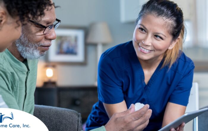 A nurse smiles as she helps an older couple with their medication in the comfort of their own home, showing the benefits of in-home nursing services.