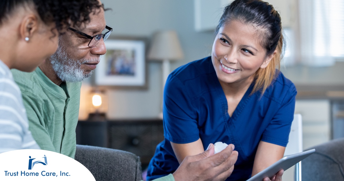 A nurse smiles as she helps an older couple with their medication in the comfort of their own home, showing the benefits of in-home nursing services.