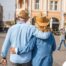 2 older adults hug while on vacation representing the successful outing that can still happen while caring for elderly loved ones.