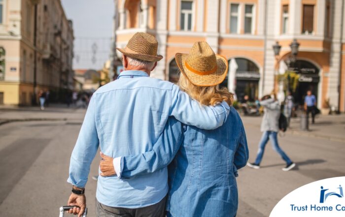 2 older adults hug while on vacation representing the successful outing that can still happen while caring for elderly loved ones.