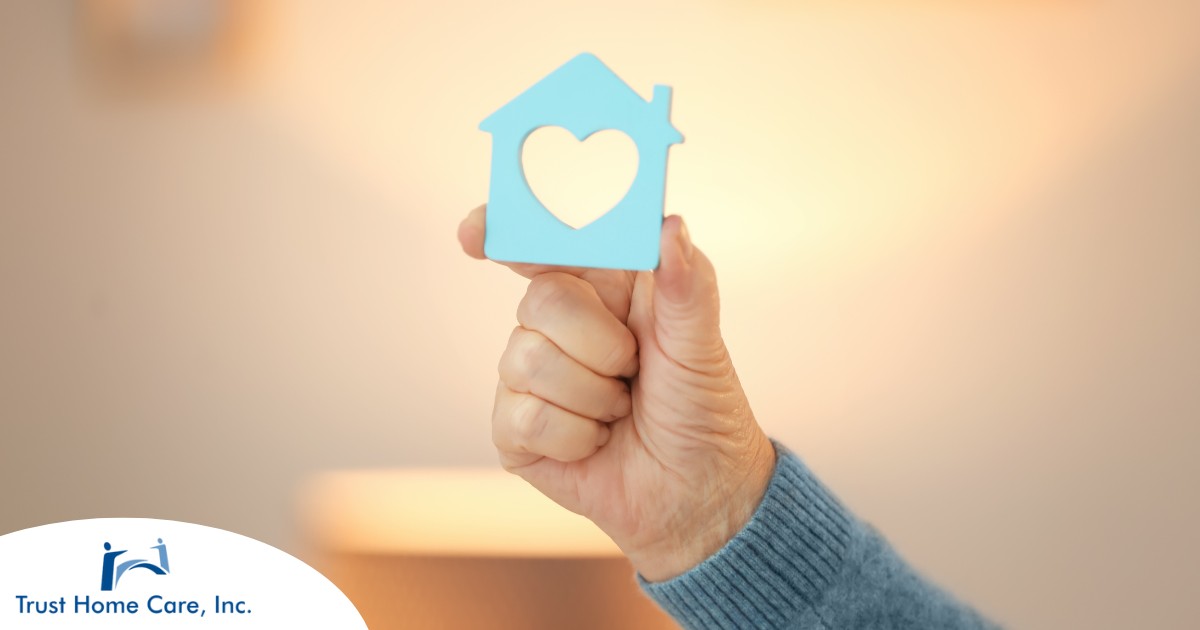 7-Facts-to-See-If-the-Home-Care-Industry-Is-Right-For-You A hand holds up a cutout of a home with a heart in it, representing the home care industry.