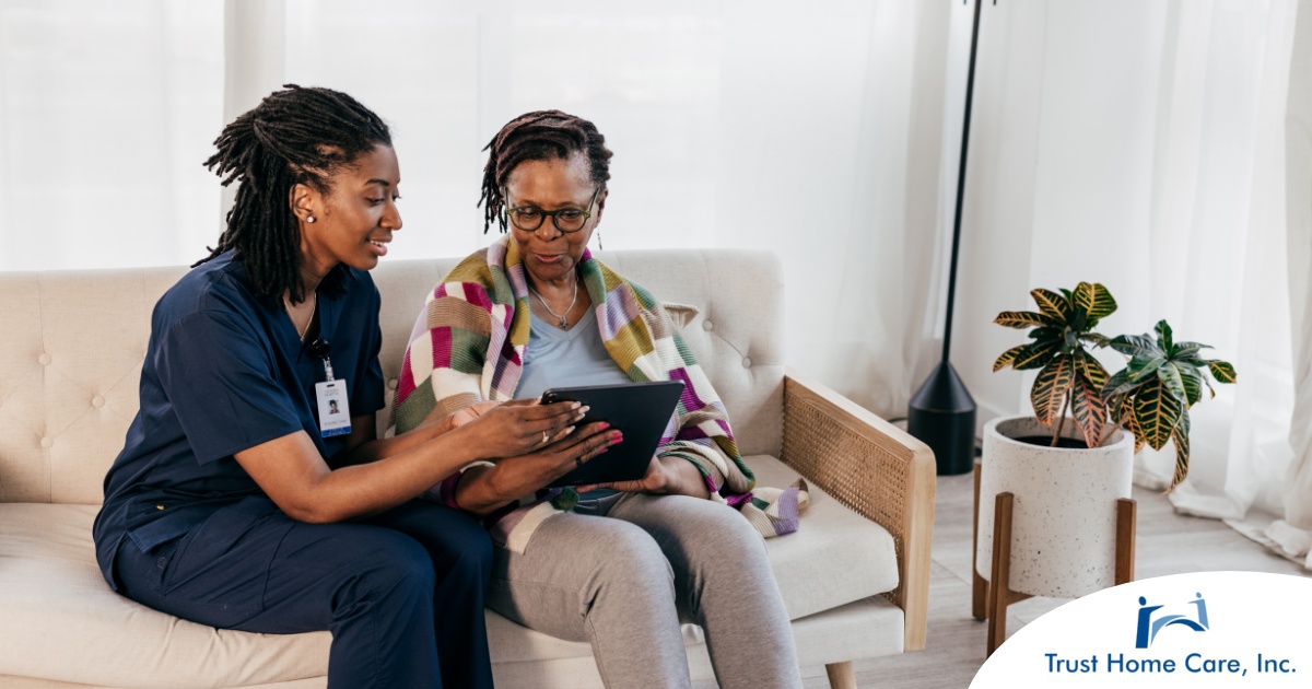 Personalized-Care-Understanding-the-Unique-Needs-of-Home-Health-Care-Patients A caregiver talks with a patient while showing her information on a tablet representing the type of thorough communication needed for effective and professional care of home health care patients.