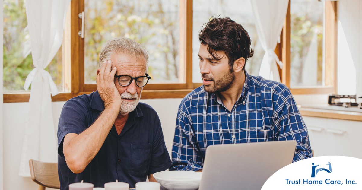 Recognizing-the-Early-Signs-of-Dementia-for-Better-Support A man looks at a computer with his father who is confused, representing one of the early signs of dementia.
