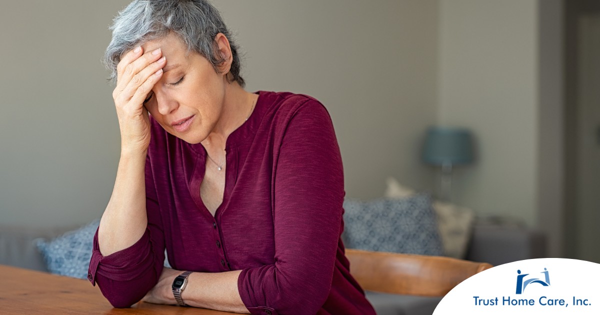 Stress-Management-for-New-Family-Caregivers-Techniques-and-Strategies A woman holds her head in her hand, representing the stress that new family caregivers go through.