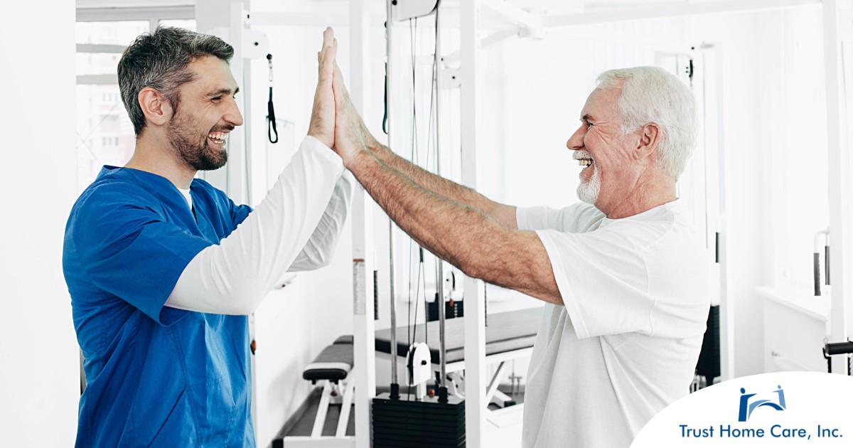 Why-Choose-a-Career-as-a-Physical-Therapy-Assistant A healthcare worker and patient smile and high five representing the satisfaction that can come from a career as a physical therapy assistant.