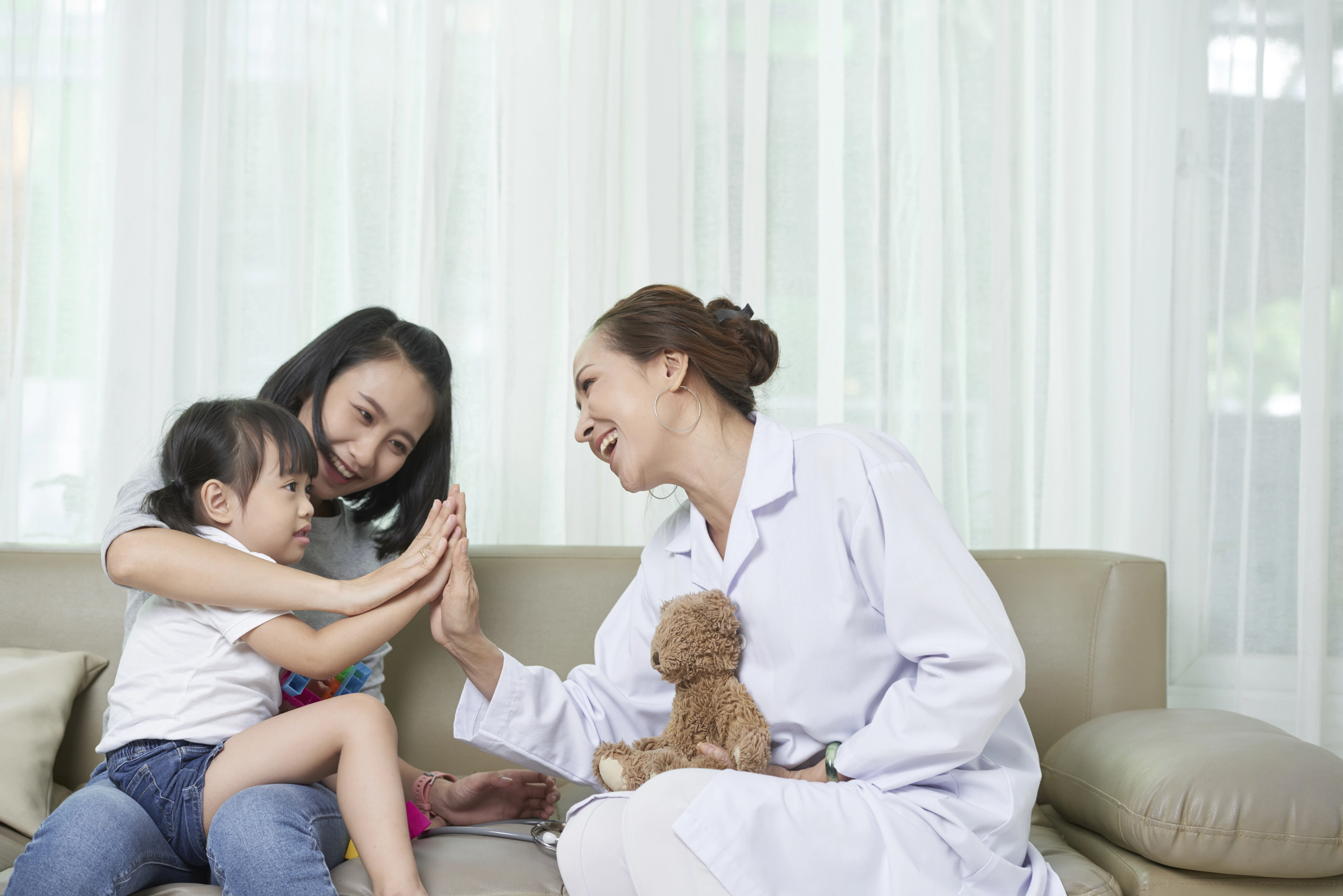 Caregiver sharing a high-five with a child at home during in-home autism care in Bowie, MD