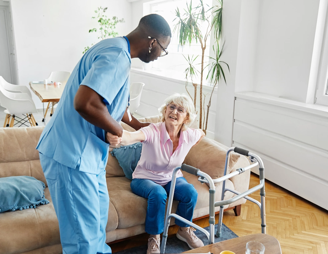 respite care Bowie, MD African American caregiver helps disabled elderly woman to stand