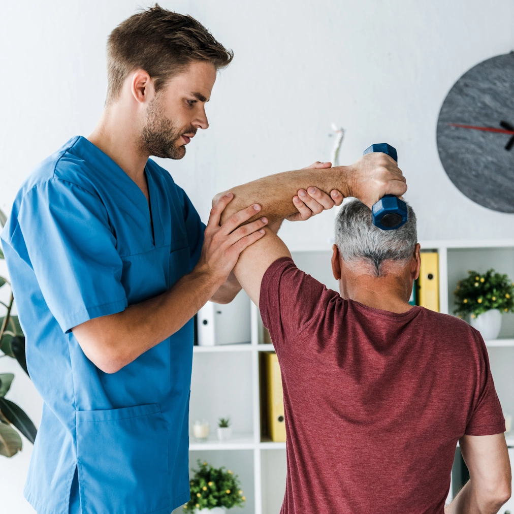 respite care Bowie, MD male caretaker helps elderly man with physical therapy