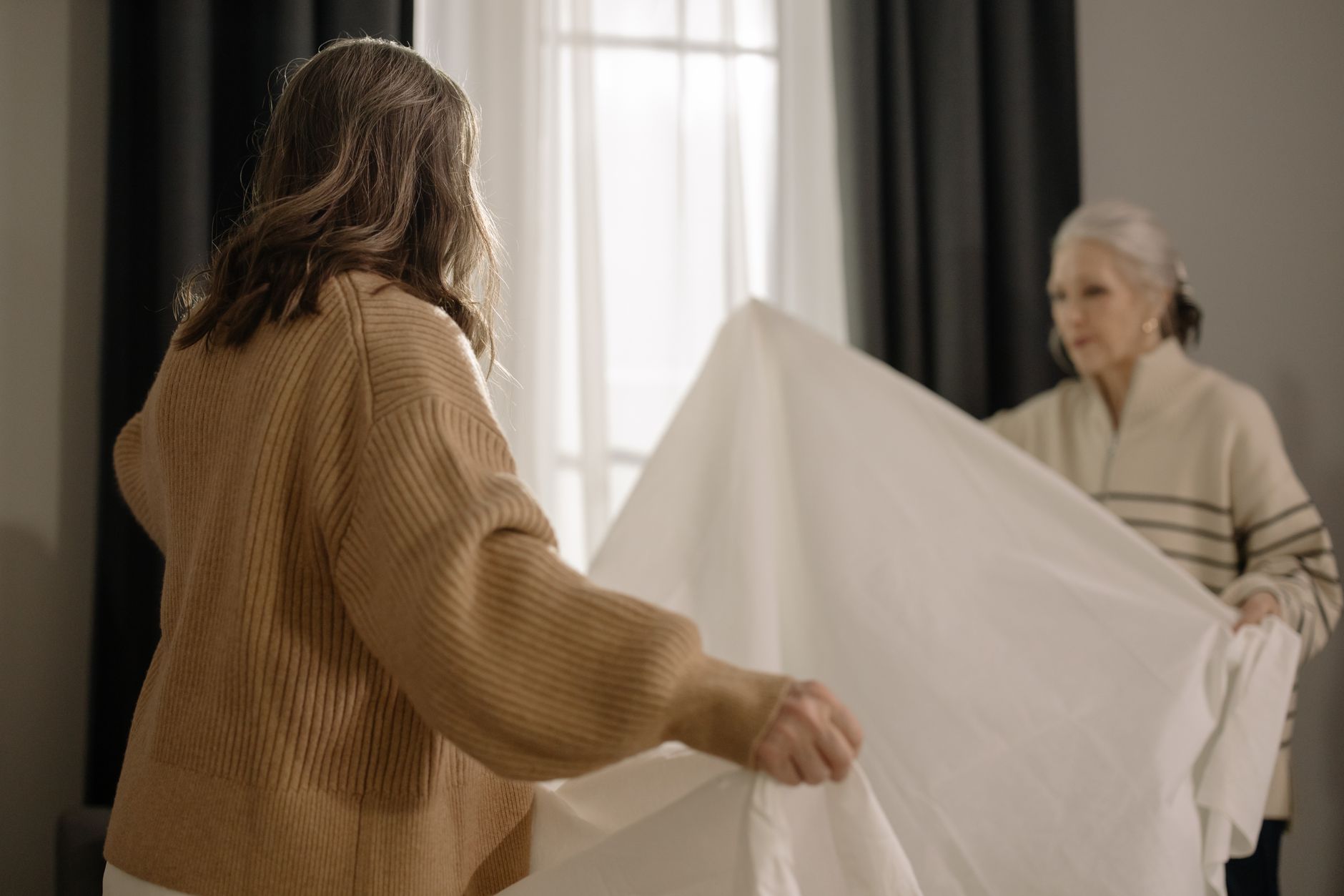 A home help caregiver making the bed with a senior woman in Sterling, VA