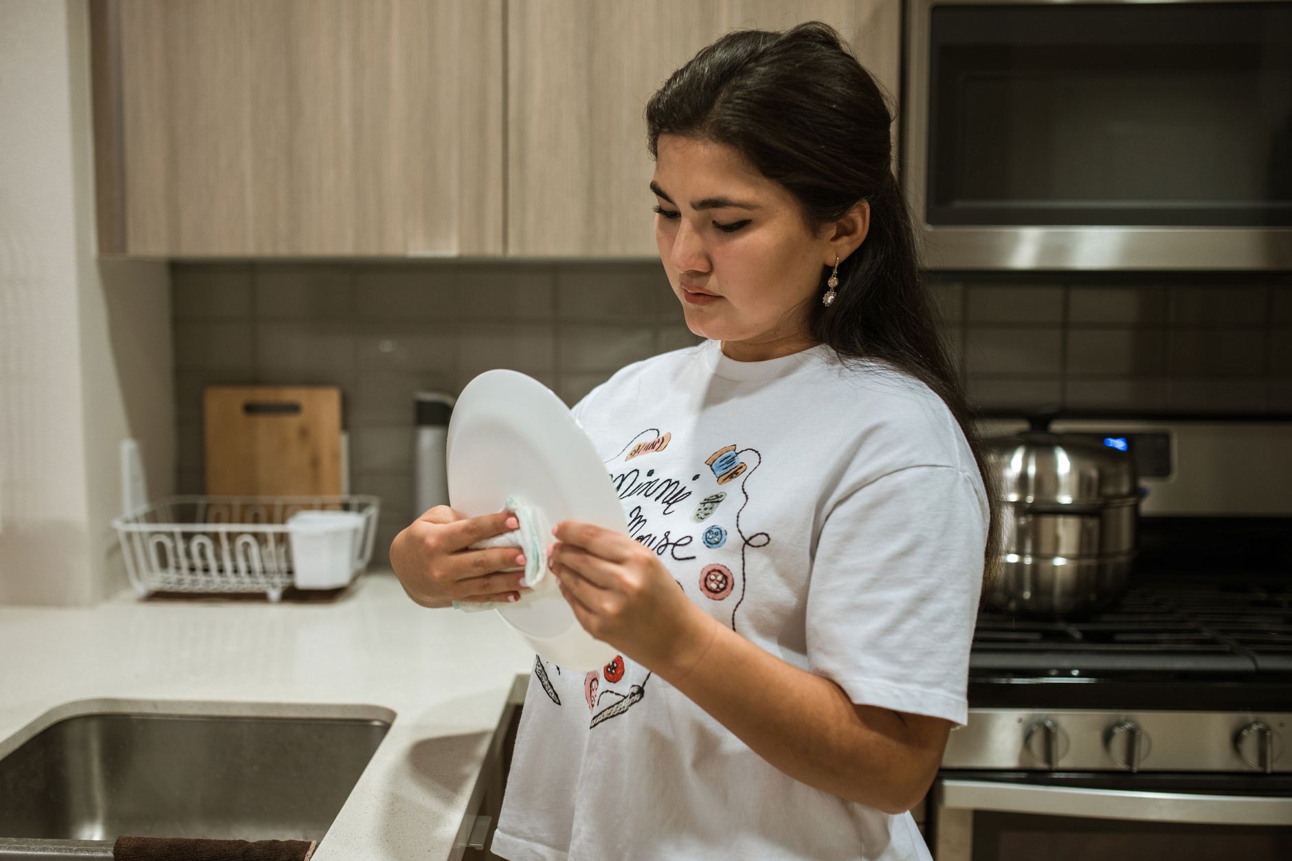 A caregiver washing dishes and tidying the kitchen during home help in Sterling, VA